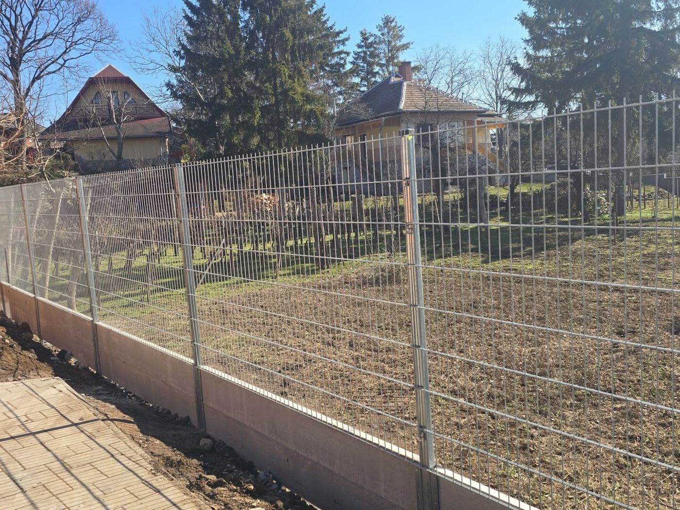 Kész horganyzott 2D táblás kerítésszakasz beton lábazaton, telekhatáron
